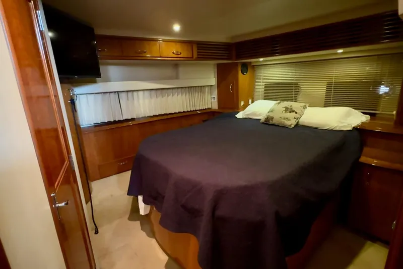  Yacht Photos Pics Luxurious bedroom interior of 2003 Carver 396 Motor Yacht with cozy bed and wooden cabinetry.