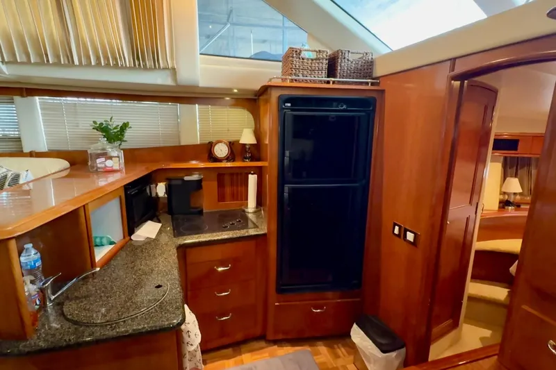  Yacht Photos Pics Luxurious kitchen interior of 2003 Carver 396 Motor Yacht with wood cabinetry and modern appliances.