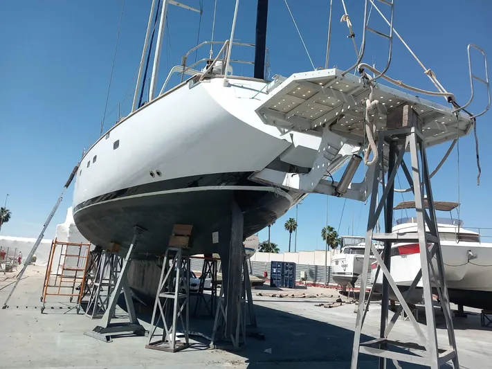  Yacht Photos Pics CIM Maxi 88 Cutter Sloop 1991 on dry dock, supported by stands, under clear blue sky.