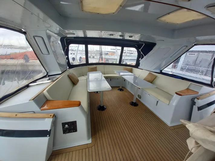  Yacht Photos Pics Spacious interior of 1991 CIM Maxi 88 Cutter Sloop with seating and tables.