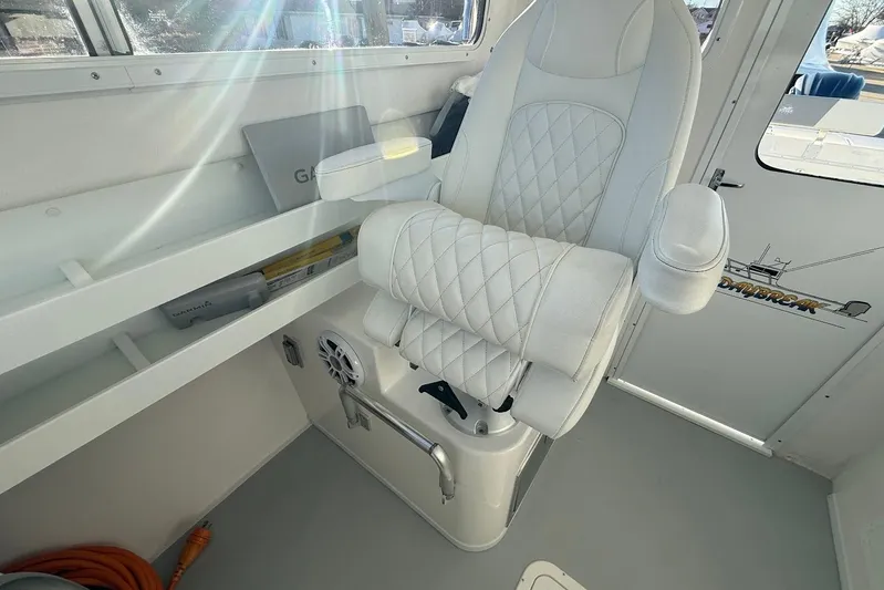 Daybreak Yacht Photos Pics Captain's chair in 2023 Steiger Craft 31 Chesapeake boat interior, featuring white quilted upholstery.