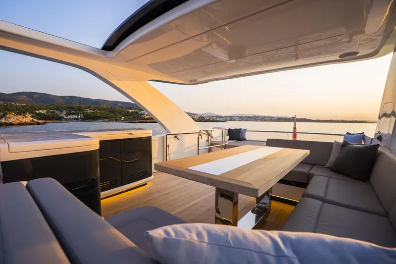 Travitude Yacht Photos Pics Luxurious Pearl 62 yacht deck with elegant seating and scenic ocean view at sunset, 2020 model.