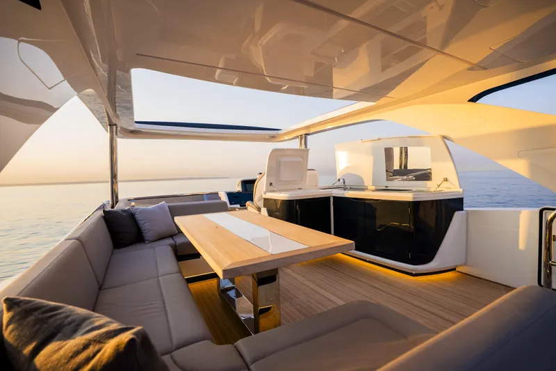 Travitude Yacht Photos Pics Luxurious 2020 Pearl 62 yacht interior with elegant seating and dining area at sunset.