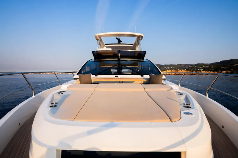 Travitude Yacht Photos Pics Luxurious 2020 Pearl 62 yacht with spacious deck, cruising on calm waters at sunset.