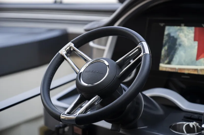 Travitude Yacht Photos Pics Steering wheel of a 2020 Pearl 62 yacht, featuring sleek design and modern controls.