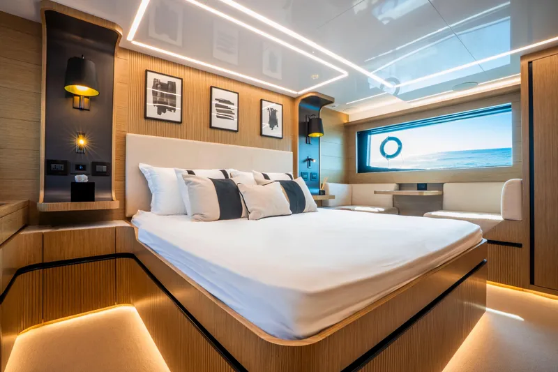 Travitude Yacht Photos Pics Luxurious bedroom interior on 2020 Pearl 62 yacht, featuring modern design and ocean view.