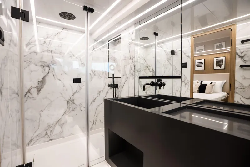 Travitude Yacht Photos Pics Luxurious modern bathroom with marble walls and sleek black fixtures in a Pearl 62 yacht.
