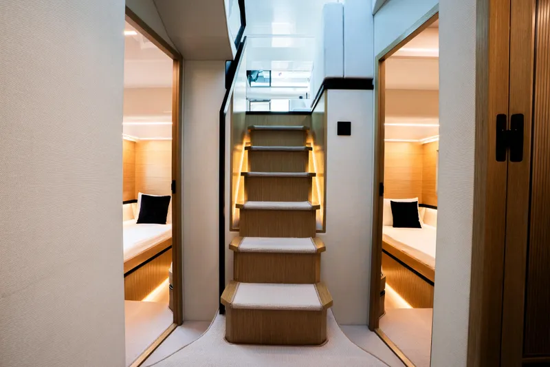 Travitude Yacht Photos Pics Luxurious interior of 2020 Pearl 62 yacht with elegant wooden stairs and cozy cabins.