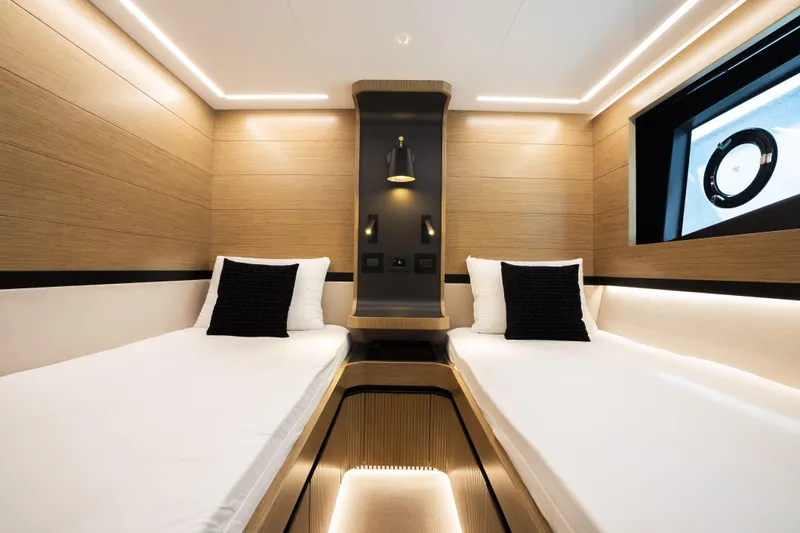 Travitude Yacht Photos Pics Luxurious twin cabin interior on 2020 Pearl 62 yacht, featuring modern design and ambient lighting.