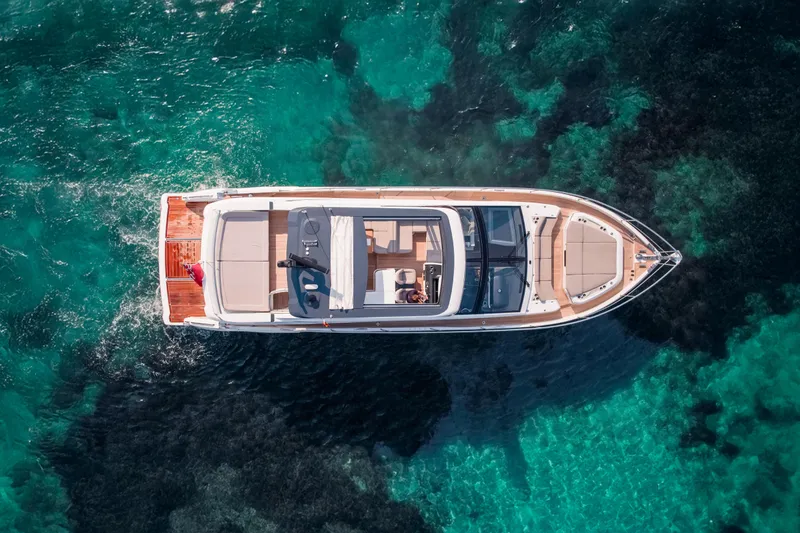 Travitude Yacht Photos Pics Aerial view of 2020 Pearl 62 yacht on clear turquoise water.