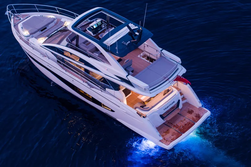 Travitude Yacht Photos Pics Luxurious 2020 Pearl 62 yacht cruising at dusk with illuminated deck and sleek design.