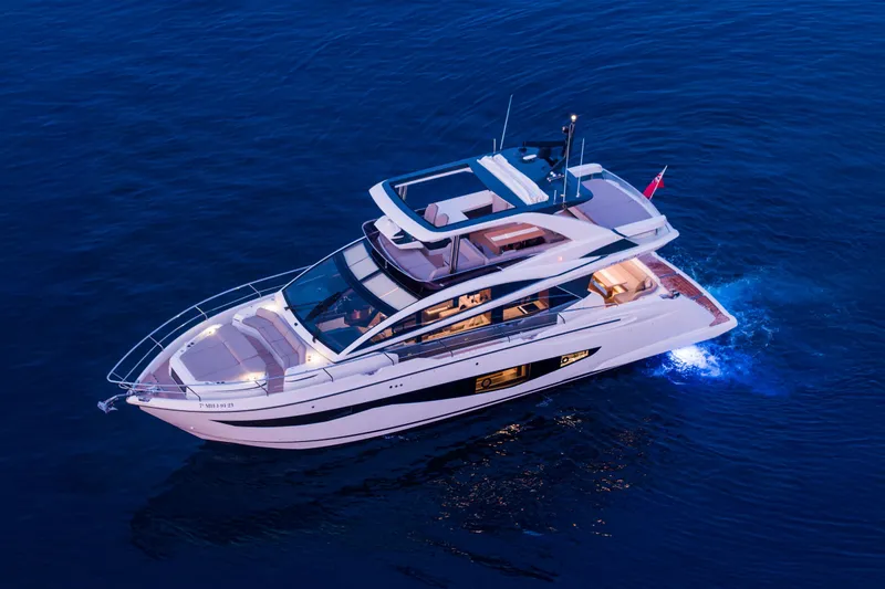 Travitude Yacht Photos Pics Luxurious 2020 Pearl 62 yacht cruising on calm blue waters at dusk.