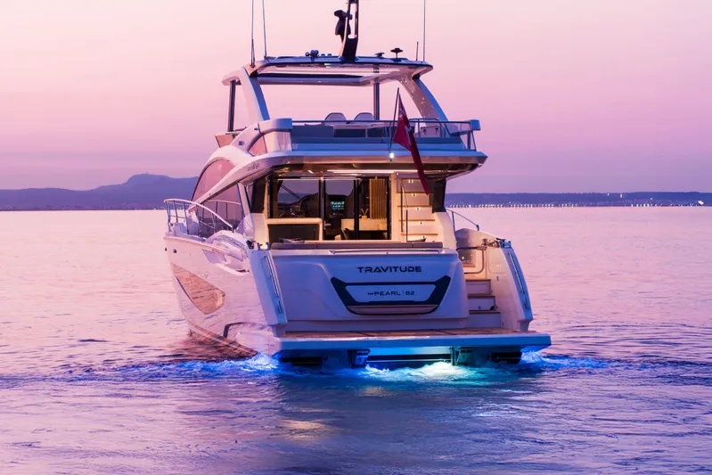 Travitude Yacht Photos Pics Luxurious 2020 Pearl 62 yacht at sunset, featuring elegant design and ambient lighting.