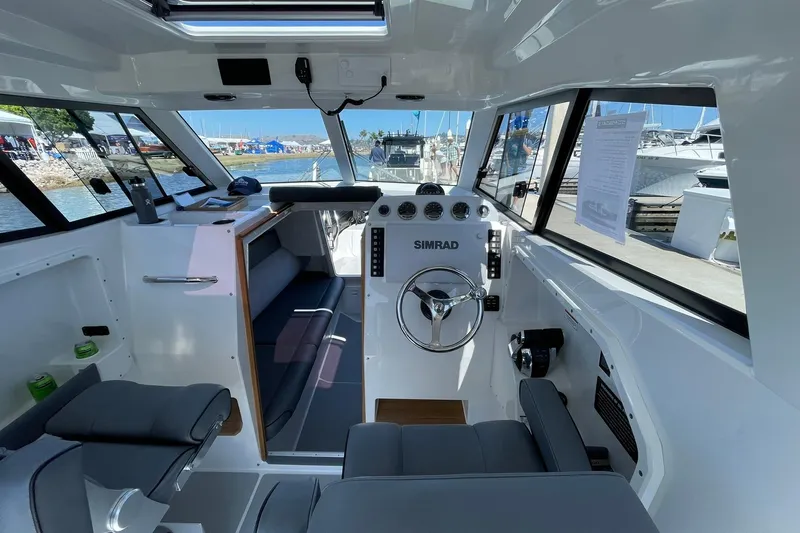  Yacht Photos Pics 2024 Protector 310 Targa boat interior with steering wheel and navigation equipment.