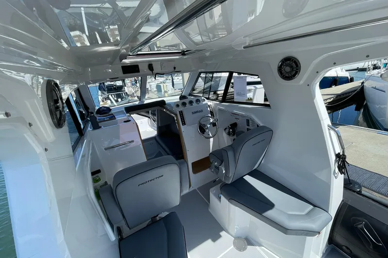  Yacht Photos Pics Interior of 2024 Protector 310 Targa boat, featuring modern seating and control panel.