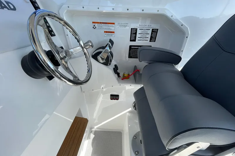  Yacht Photos Pics 2024 Protector 310 Targa boat cockpit with steering wheel and comfortable seating.