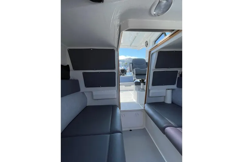  Yacht Photos Pics Interior view of 2024 Protector 310 Targa boat, featuring seating and helm area.