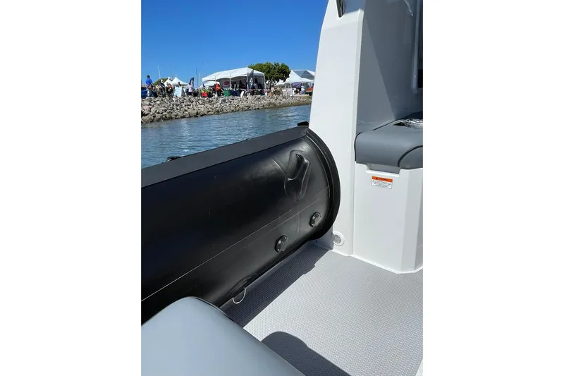  Yacht Photos Pics 2024 Protector 310 Targa boat interior with seating, dockside view, and clear blue sky.