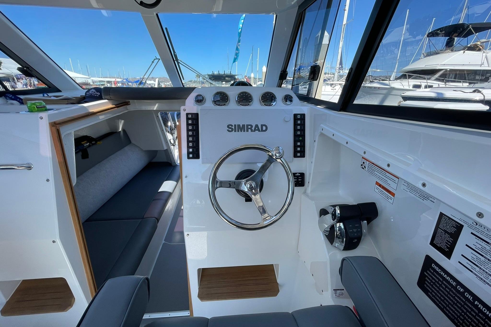 2024 Protector 310 Targa boat interior with steering wheel and control panel.