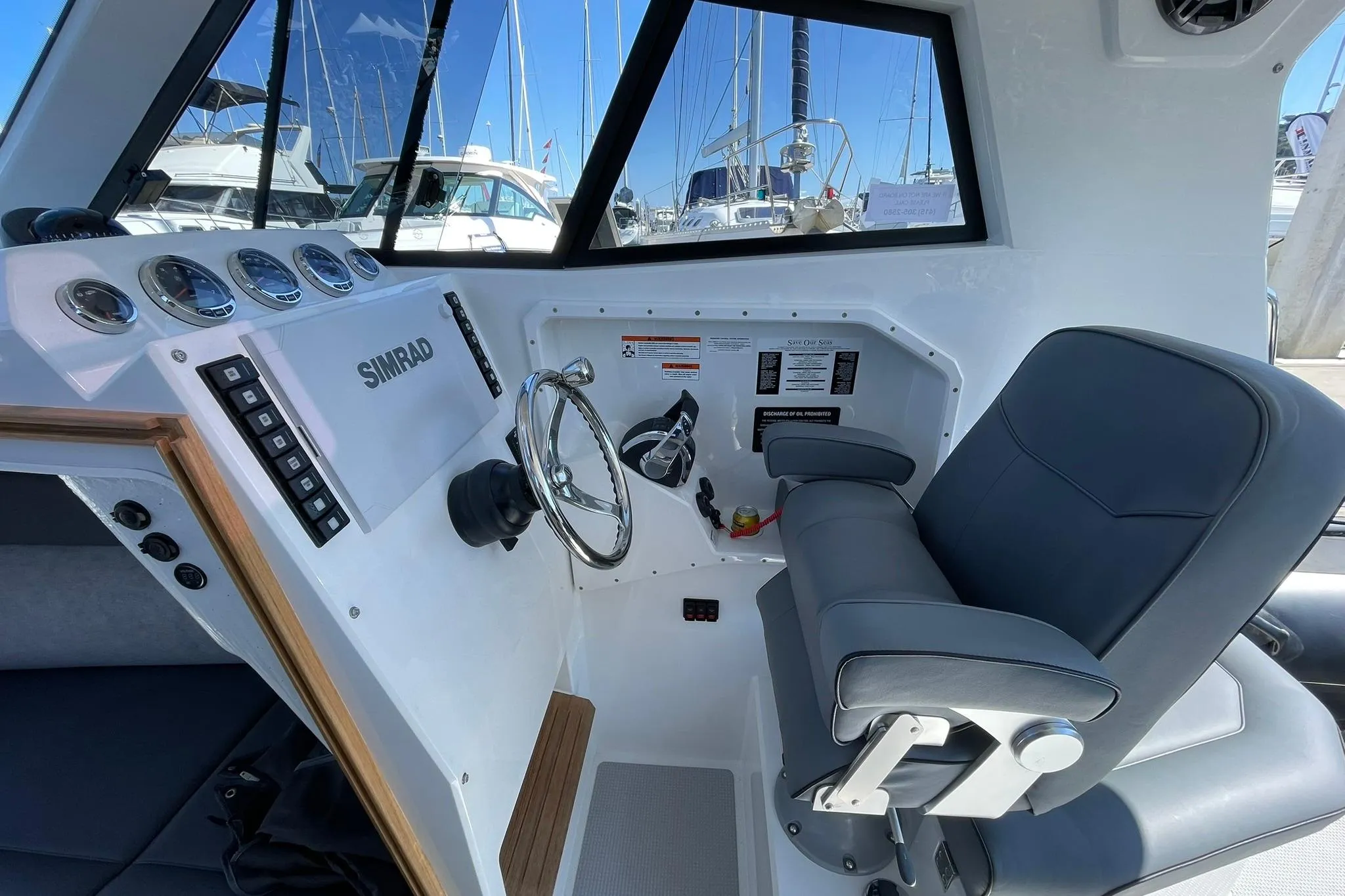 2024 Protector 310 Targa boat interior with steering wheel and control panel.