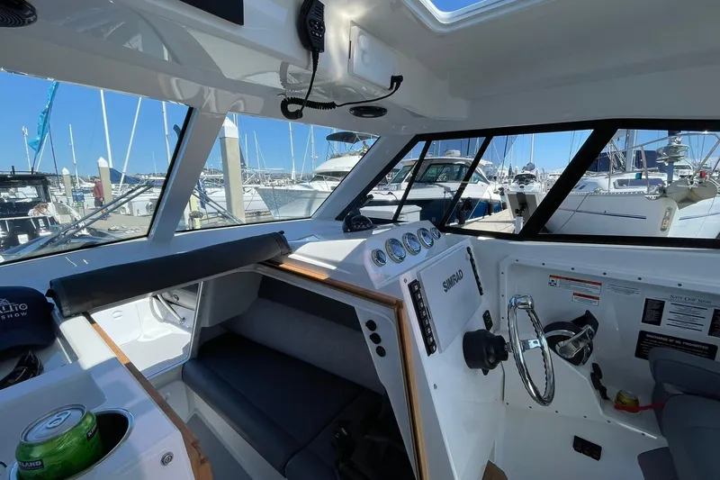 Yacht Photos Pics Interior of 2024 Protector 310 Targa boat, featuring modern controls and marina view.