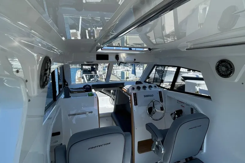  Yacht Photos Pics Interior of 2024 Protector 310 Targa boat, featuring modern controls and seating.