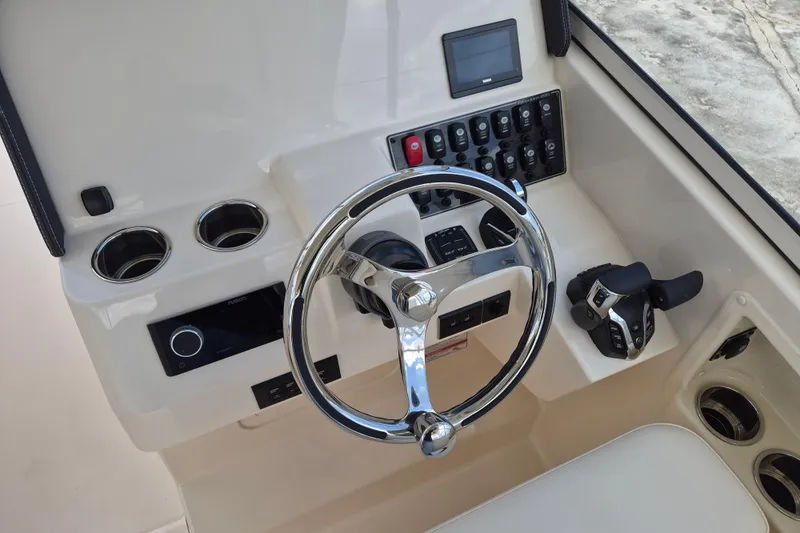 285-662 Yacht Photos Pics 2026 Grady-White Freedom 285 helm with steering wheel, controls, and cup holders.