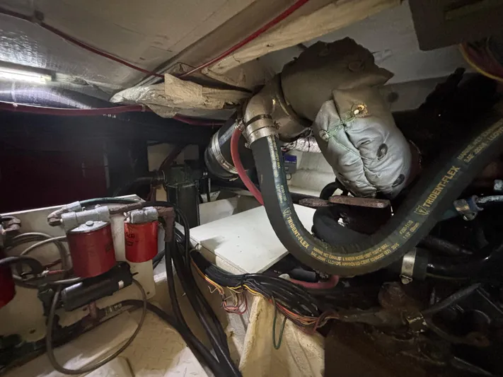  Yacht Photos Pics Engine room of a 1994 Bayliner 4700, showing hoses, filters, and mechanical components.