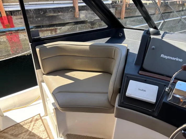  Yacht Photos Pics Captain's seat on a 1994 Bayliner 4700 yacht, featuring Raymarine navigation equipment.