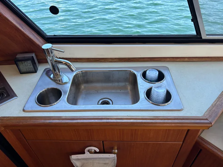  Yacht Photos Pics Bayliner 4700 yacht kitchen sink with faucet, 1994 model, overlooking water through window.