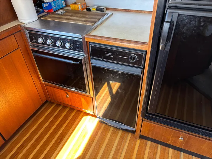 Yacht Photos Pics 1994 Bayliner 4700 yacht kitchen with stove, dishwasher, and wood flooring.