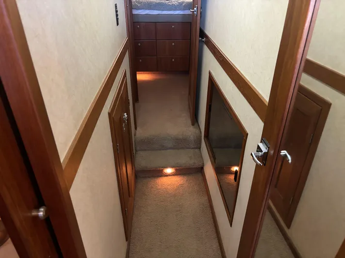  Yacht Photos Pics Interior hallway of a 1994 Bayliner 4700 yacht with carpeted steps and wooden accents.