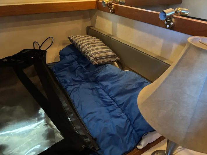  Yacht Photos Pics Cozy cabin interior of 1994 Bayliner 4700 with blue sleeping bag and striped pillow.