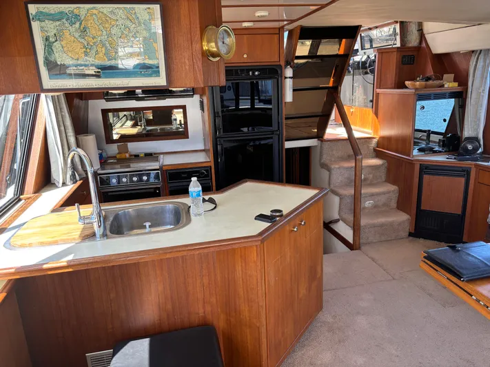  Yacht Photos Pics Interior of a 1994 Bayliner 4700 yacht with kitchen and stairs, featuring wood cabinetry.