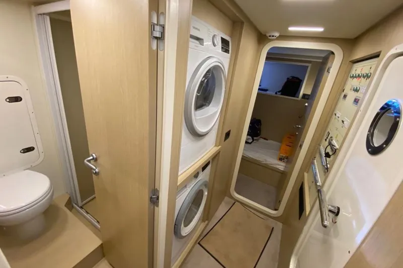  Yacht Photos Pics Laundry area and bathroom inside a 2022 Ferretti Yachts 720, featuring modern appliances.