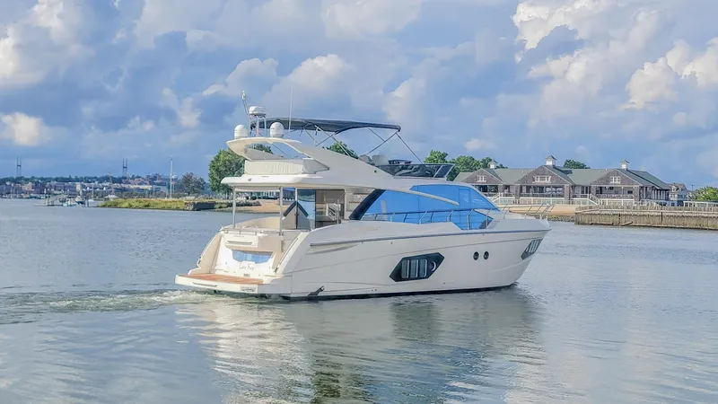 Low Key Yacht Photos Pics 2019 Absolute 50 Fly yacht cruising on a calm river under a cloudy sky.