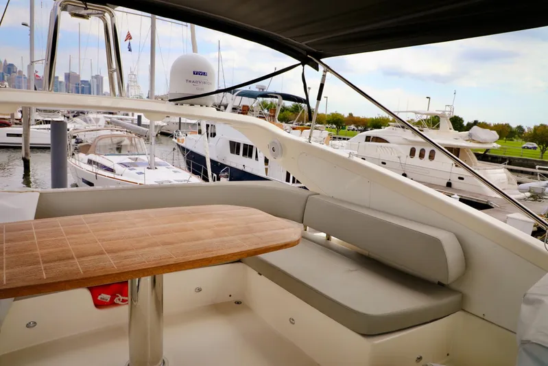 Low Key Yacht Photos Pics Flybridge seating area on 2019 Absolute 50 Fly yacht, docked with other luxury boats.