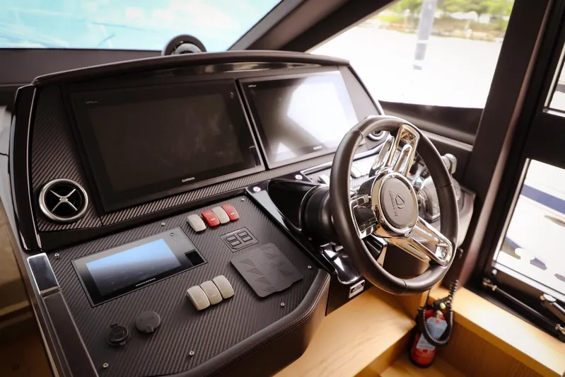 Low Key Yacht Photos Pics Control panel of a 2019 Absolute 50 Fly yacht with modern steering and displays.