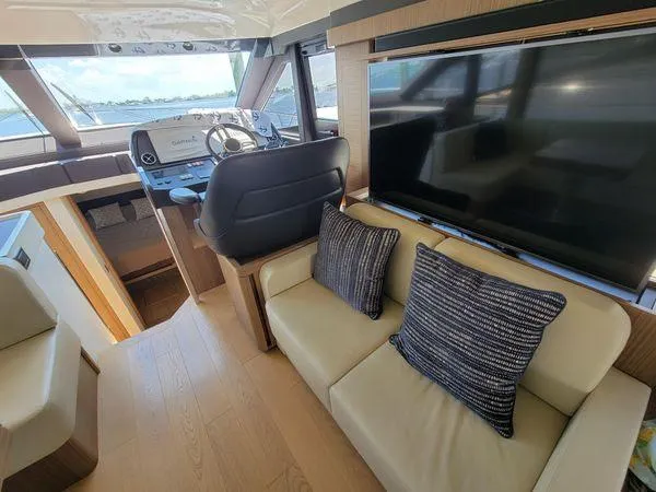 Low Key Yacht Photos Pics Interior of 2019 Absolute 50 Fly yacht with helm, seating, and large TV.