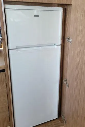 Low Key Yacht Photos Pics White refrigerator in wooden cabinet on 2019 Absolute 50 Fly yacht.