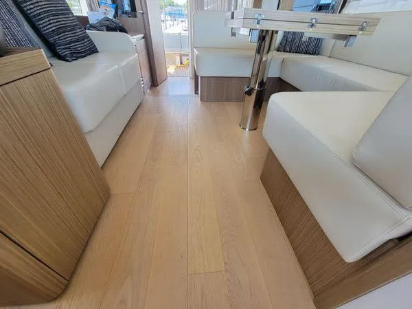 Low Key Yacht Photos Pics Luxurious interior of 2019 Absolute 50 Fly yacht with wooden flooring and white seating.