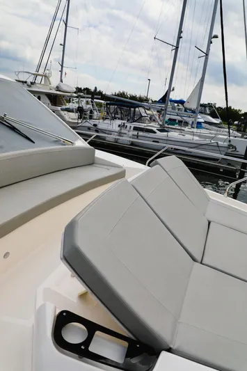 Low Key Yacht Photos Pics 2019 Absolute 50 Fly yacht with sleek seating, docked among sailboats.