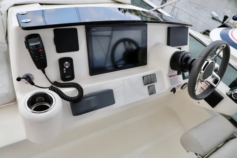 Low Key Yacht Photos Pics Control panel of 2019 Absolute 50 Fly yacht with navigation screen and steering wheel.