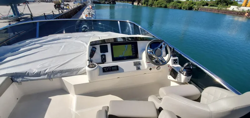 Low Key Yacht Photos Pics 2019 Absolute 50 Fly yacht helm with navigation system, docked by a serene waterway.