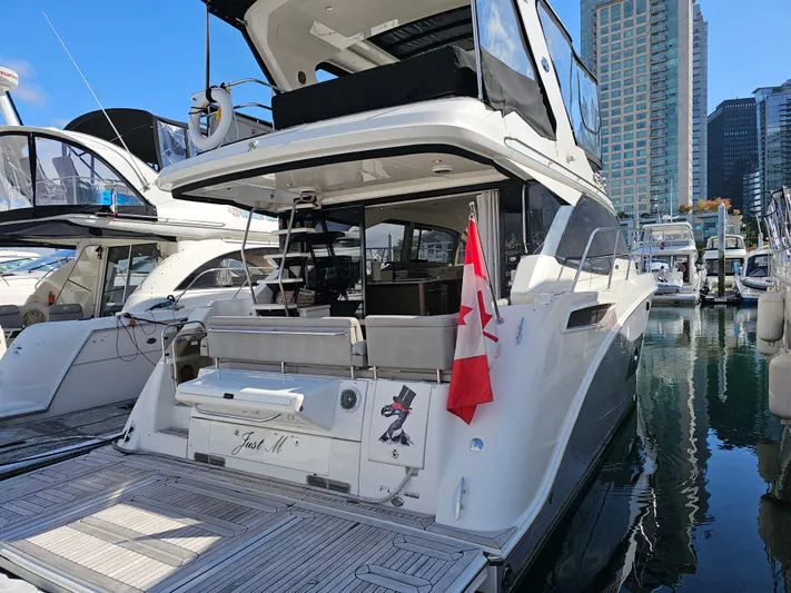 Just M Yacht Photos Pics 2018 Sea Ray Fly 460 yacht docked, featuring a Canadian flag and modern marina backdrop.