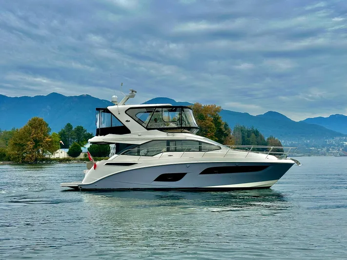 Just M Yacht Photos Pics 2018 Sea Ray Fly 460 yacht cruising on a scenic lake with mountains in the background.