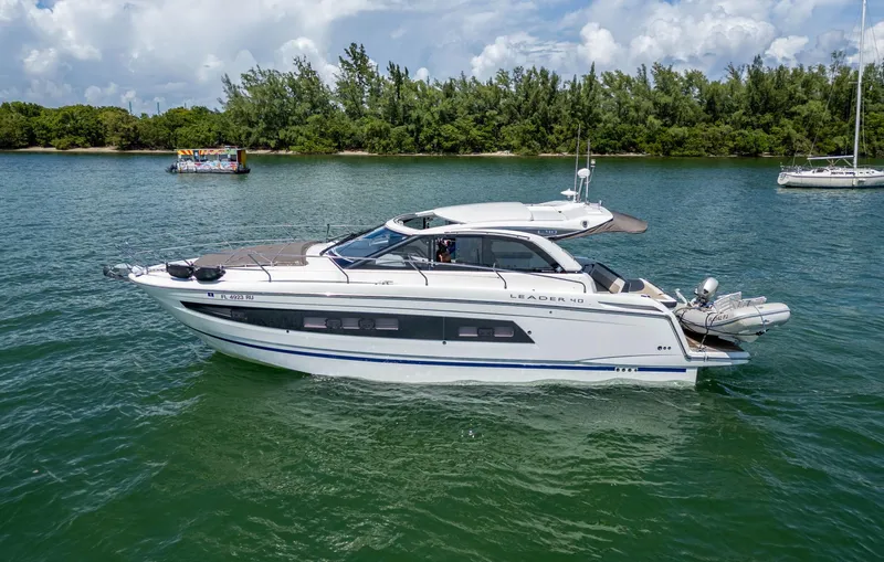  Yacht Photos Pics 2019 Jeanneau Leader 40 yacht cruising on a serene lake with lush greenery.