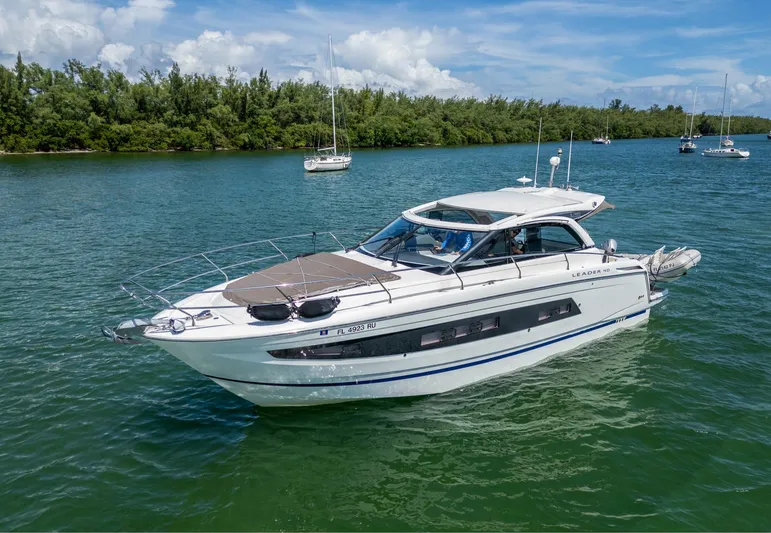  Yacht Photos Pics 2019 Jeanneau Leader 40 yacht cruising on a serene lake with lush greenery.