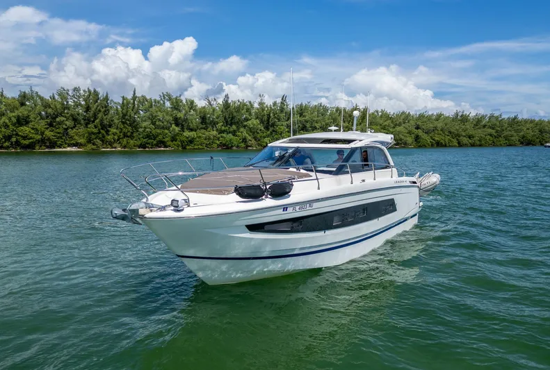  Yacht Photos Pics 2019 Jeanneau Leader 40 yacht cruising on a serene waterway under a clear blue sky.