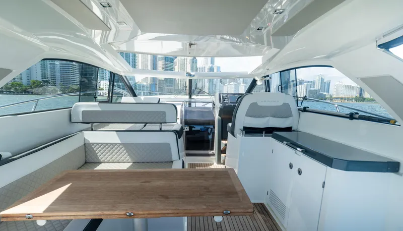  Yacht Photos Pics 2019 Jeanneau Leader 40 yacht interior with modern seating and wooden table, cityscape view.